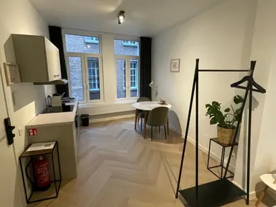 a kitchen and dining room with a table in a room at Stadsstudio op toplocatie in Antwerp