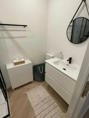 a white bathroom with a sink and a mirror at Stadsstudio op toplocatie in Antwerp