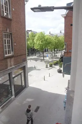 a man standing outside of a building looking at a courtyard at Stadsstudio op toplocatie in Antwerp
