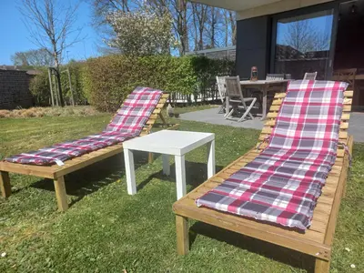 two benches with plaid cushions sitting next to a table at Monastery Garden - 2 single and little rooms - bed & free breakfast - shared accomodation where landlord lives in Wezembeek-Oppem