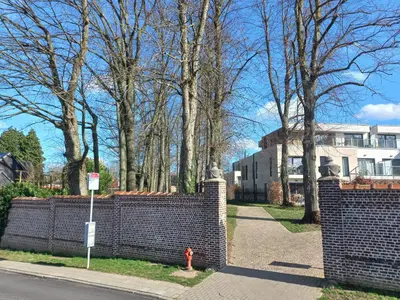a brick fence with a fire hydrant in front of a house at Monastery Garden - 2 single and little rooms - bed & free breakfast - shared accomodation where landlord lives in Wezembeek-Oppem