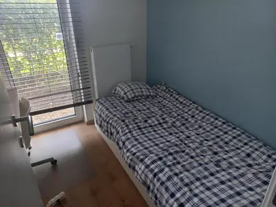 a bedroom with a bed in a room with a window at Monastery Garden - 2 single and little rooms - bed & free breakfast - shared accomodation where landlord lives in Wezembeek-Oppem