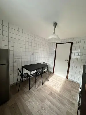 a room with a table and chairs and a refrigerator at chill corner in Brussels