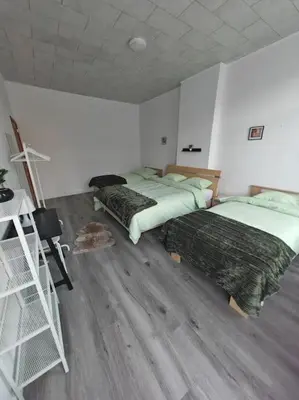 two beds in a room with wooden floors at The Castle in Niel