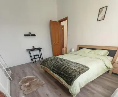 a bedroom with a large bed and a wooden floor at The Castle in Niel