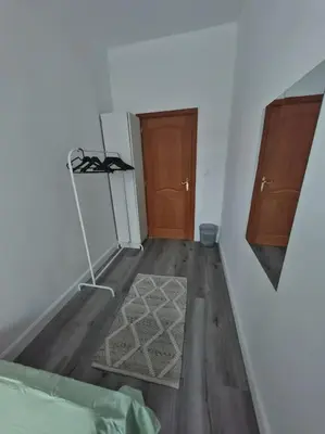 a room with a kitchen with a refrigerator and wooden floors at The Castle in Niel