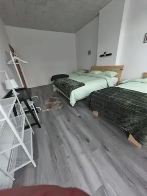 a bedroom with two beds and a wooden floor at The Castle in Niel