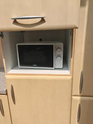 a microwave oven sitting inside of a cabinet at The Castle in Niel
