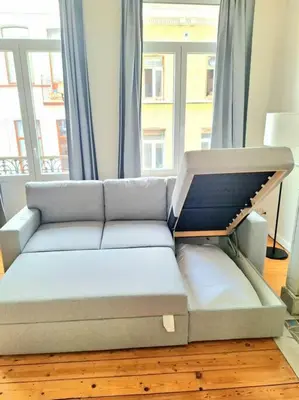 a couch in a living room with a large window at La Suite Alice in Brussels