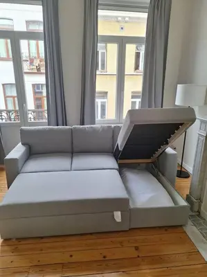 a couch in a living room with a large window at Le Duplex-suite Joséphine in Brussels