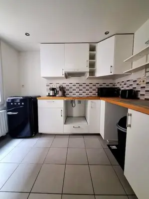 a kitchen with white cabinets and a tile floor at Le Duplex-suite Joséphine in Brussels