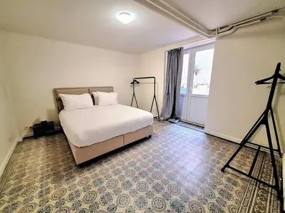 a bedroom with a bed and a large window at Le Duplex-suite Joséphine in Brussels