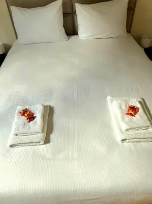 a bed with two towels with red flowers on it at La Suite Julienne in Brussels