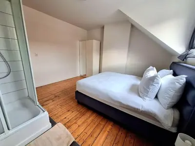 a bedroom with a bed with white sheets and pillows at La Suite Julienne in Brussels