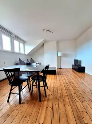 a dining room with a table and chairs on a wooden floor at La Suite Julienne in Brussels