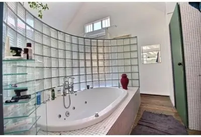 a bathroom with a large tub with a glass wall at Le loft des artistes in Brussels