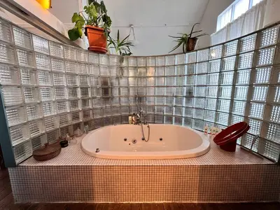 a bathroom with a tub with plants on the wall at Le loft des artistes in Brussels