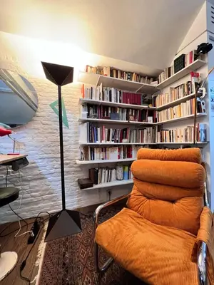 a living room with a couch and book shelves with books at Le loft des artistes in Brussels