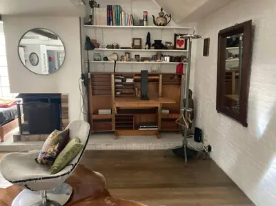 a living room with a chair and a mirror at Le loft des artistes in Brussels