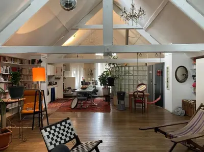 an attic room with chairs and a table in it at Le loft des artistes in Brussels