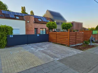a house with a fence with solar panels on it at B&B Tlekkerbeddeke in Rumst