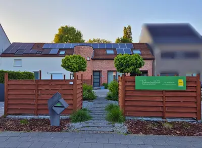 a house with solar panels on top of a fence at B&B Tlekkerbeddeke in Rumst