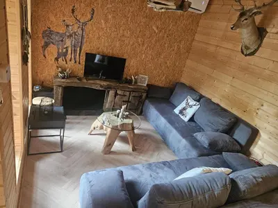 a living room with a blue couch and a table at Casa De Los Ciervos in Stekene