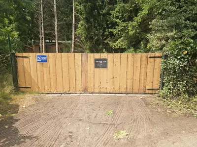 a wooden fence with a gate with a sign on it at Casa De Los Ciervos in Stekene
