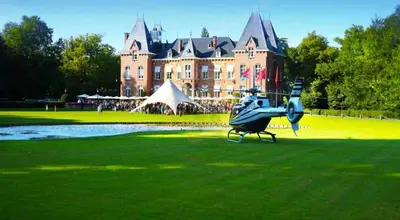 a helicopter sitting on the grass in front of a castle at Château à 10 minutes de Bruxelles in Beersel