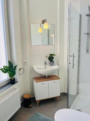 a white bathroom with a sink and a shower at Clemençon by BLOSS in Ghent