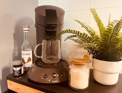 a coffee maker sitting on a counter with a plant at Clemençon by BLOSS in Ghent