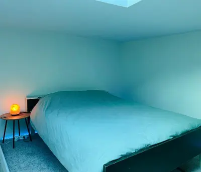 a bedroom with a bed and a table with a lamp at Clemençon by BLOSS in Ghent