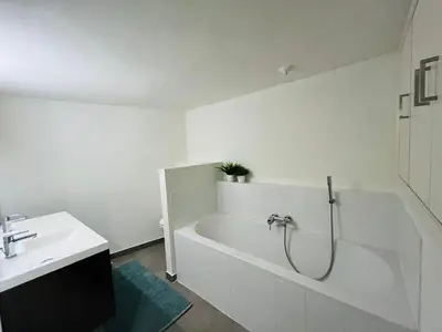 a white bathroom with a tub and a sink at Clemençon by BLOSS in Ghent