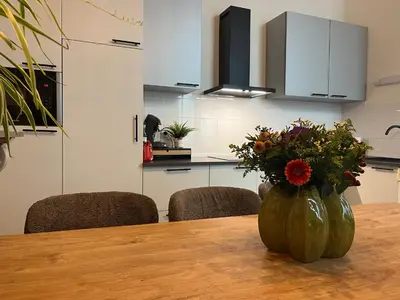 a vase of flowers sitting on a table in a kitchen at Clemençon by BLOSS in Ghent