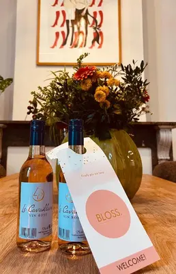 two bottles of wine on a table with a vase at Clemençon by BLOSS in Ghent