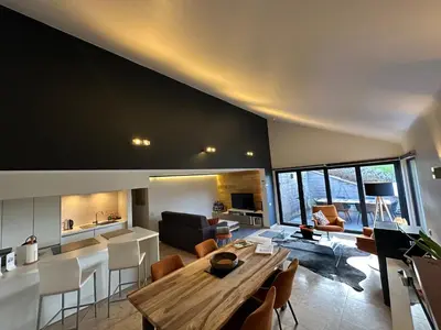 a large living room with a wooden table and chairs at Sakura Lodging in Bossut-Gottechain