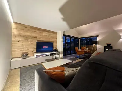 a living room with a couch and a flat screen tv at Sakura Lodging in Bossut-Gottechain