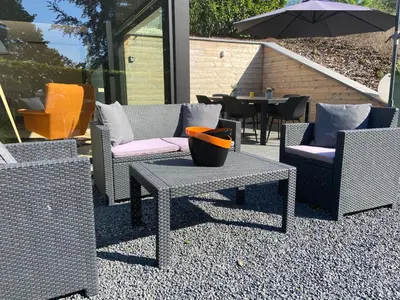 a group of chairs and tables and an umbrella at Sakura Lodging in Bossut-Gottechain