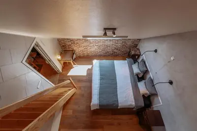 a small room with a bed and a brick wall at De Bronne in Herzele