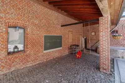a brick building with a chalkboard on the side of it at De Bronne in Herzele
