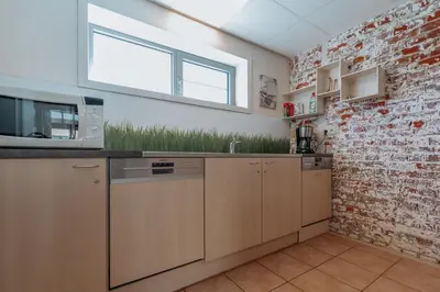 a kitchen with a brick wall and a window at De Bronne in Herzele