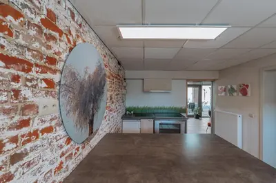 a kitchen with a brick wall and a mirror on the wall at De Bronne in Herzele