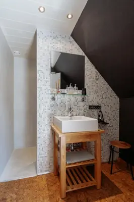 a bathroom with a sink on a wall with tiles at De Bronne in Herzele