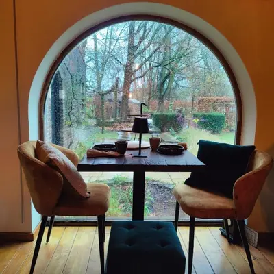 a table in a room with a large window at Peace in Assenede