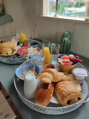a table topped with a plate of pastries and eggs at Peace in Assenede