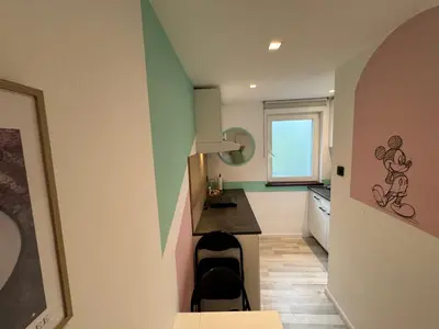 a room with a kitchen with a counter and a table at hébergement pour 3 personnes, 2 chambres in Overijse