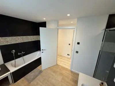 a bathroom with a bath tub and a sink at hébergement pour 3 personnes, 2 chambres in Overijse