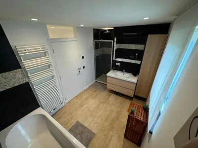 a small bathroom with a tub and a sink at hébergement pour 3 personnes, 2 chambres in Overijse