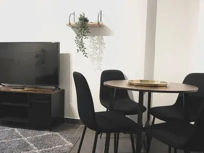 a dining room with a table and chairs and a television at Duden Park Brussels - Cosy APT 1 Bedroom in Brussels
