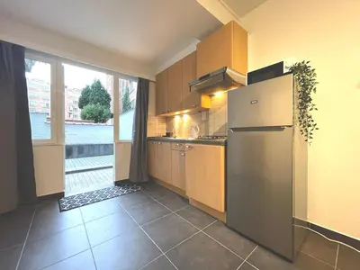 a kitchen with a refrigerator and a large window at Duden Park Brussels - Cosy APT 1 Bedroom in Brussels